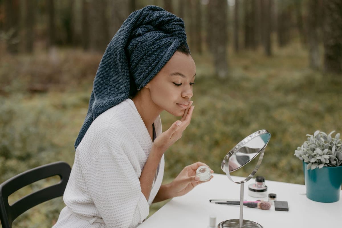 Tinted mineral sunscreen being blended along a cheekbone in daylight